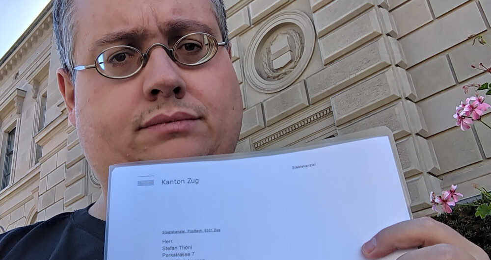 Selfie von Stefan Thöni vor dem Zuger Regierungsgebäude mit der Eingangsbestätigung für den Wahlvorschlag