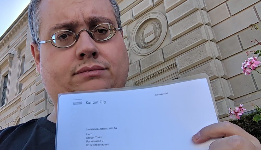 Selfie von Stefan Thöni vor dem Zuger Regierungsgebäude mit der Eingangsbestätigung für den Wahlvorschlag