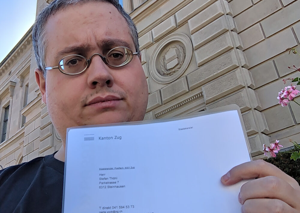 Selfie von Stefan Thöni vor dem Zuger Regierungsgebäude mit der Eingangsbestätigung für den Wahlvorschlag